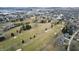 Panoramic aerial view of a golf course community with well-maintained homes, interspersed trees, and serene lakes at 2109 Elmwood Dr, Lebanon, IN 46052