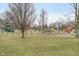 Expansive playground featuring slides, swings, and climbing structures, surrounded by green grass and trees at 2109 Elmwood Dr, Lebanon, IN 46052