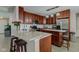 A kitchen featuring wood cabinets, stainless steel appliances, a granite island, and subway tile backsplash at 2180 Quarter Path Rd, Cicero, IN 46034