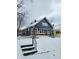 Charming blue bungalow with brick foundation, multiple windows, and snow-covered yard at 2309 N Dearborn St, Indianapolis, IN 46218