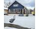 A cozy blue bungalow with brick accents and a snow-covered front yard at 2309 N Dearborn St, Indianapolis, IN 46218