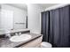 Bright bathroom features a granite countertop vanity and a shower with a dark colored curtain at 2357 Central Ave, Indianapolis, IN 46205
