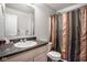 Bright bathroom features a granite countertop vanity and a shower with a multi-colored curtain at 2357 Central Ave, Indianapolis, IN 46205