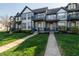 Well-maintained townhome featuring blue trim, lush lawn, and welcoming entryway at 2357 Central Ave, Indianapolis, IN 46205