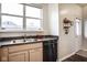 A bright kitchen featuring a window, stainless steel dishwasher, and light wood cabinets at 2357 Central Ave, Indianapolis, IN 46205