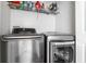 Modern laundry room with stainless steel washer and dryer, and shelving for storage at 2357 Central Ave, Indianapolis, IN 46205