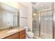 Bright bathroom featuring a granite-topped vanity and glass enclosed shower with decorative tile accents at 2564 Tangleridge Ln, Brownsburg, IN 46112