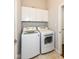Functional laundry room with white cabinets, washer, dryer and tiled flooring at 2564 Tangleridge Ln, Brownsburg, IN 46112