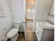 Bathroom featuring a toilet, sink, and view into the kitchen from the door at 3049 Foltz St, Indianapolis, IN 46241