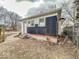Home's side exterior view, showing partial renovation, backyard, and various outbuildings at 3049 Foltz St, Indianapolis, IN 46241