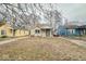 Street view showcasing this cozy home with covered entry surrounded by mature trees at 3829 N Temple Ave, Indianapolis, IN 46205