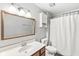 Bathroom showcasing a vanity with a sink, toilet, and a shower with a white curtain at 3986 Braddock Rd, Indianapolis, IN 46268