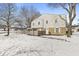 Charming exterior featuring a brick foundation, siding, and a fenced in yard covered in snow at 3986 Braddock Rd, Indianapolis, IN 46268