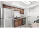 Kitchen featuring stainless steel appliances, dark cabinetry, laminate countertops and wood-look flooring at 3986 Braddock Rd, Indianapolis, IN 46268
