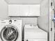Convenient laundry area with a modern Samsung washer, Whirlpool dryer, and overhead storage cabinets at 3986 Braddock Rd, Indianapolis, IN 46268