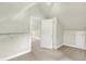 Bright attic space featuring neutral carpeting, closet, shelving, and doorway to another room at 4029 Broadway St, Indianapolis, IN 46205