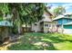 Landscaped backyard features a lush green lawn, mature tree, exterior of the house, and a neighboring property at 4029 Broadway St, Indianapolis, IN 46205