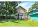 Backyard with a well-maintained lawn, mature tree, the rear of the house, and a neighboring house at 4029 Broadway St, Indianapolis, IN 46205