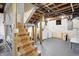 Unfinished basement area featuring a staircase, a washer and dryer, and exposed ductwork and beams at 4029 Broadway St, Indianapolis, IN 46205