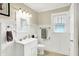 Bathroom with a pedestal sink, white wainscotting and a large window at 4029 Broadway St, Indianapolis, IN 46205