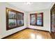 Bedroom featuring hardwood floors, neutral paint, wooden trim and two windows at 4029 Broadway St, Indianapolis, IN 46205