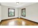 Bright bedroom featuring hardwood floors, two windows, and neutral paint at 4029 Broadway St, Indianapolis, IN 46205