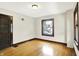 Bright bedroom featuring hardwood floors, a window, neutral paint, and wooden door at 4029 Broadway St, Indianapolis, IN 46205