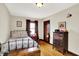 Bedroom with finished wood floor, metal-framed bed, and decorative art, highlighted by natural light at 4029 Broadway St, Indianapolis, IN 46205