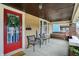 Inviting covered porch featuring outdoor seating, string lights, and a vibrant red front door at 4029 Broadway St, Indianapolis, IN 46205