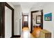 Hallway featuring wood floors, dark trim, and access to a front door and a bedroom at 4029 Broadway St, Indianapolis, IN 46205