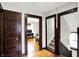 Hallway with original wood floors, dark trim, and access to a bedroom and stairs at 4029 Broadway St, Indianapolis, IN 46205