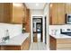 Galley kitchen with wooden cabinets, stone countertops and white backsplash tile at 4029 Broadway St, Indianapolis, IN 46205