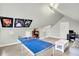 Finished attic space featuring neutral walls, carpeting, a gray couch, and a table tennis setup at 4029 Broadway St, Indianapolis, IN 46205