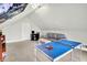Finished attic space featuring neutral walls, carpeting, a gray couch, and a table tennis setup at 4029 Broadway St, Indianapolis, IN 46205