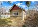 Quaint backyard shed with horizontal siding and a striking red roof under a partly cloudy sky at 4029 Broadway St, Indianapolis, IN 46205