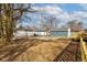 Backyard view showing a gray house with a new wood porch and a new fence, with garages visible at 4804 Brouse Ave, Indianapolis, IN 46205