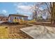 Backyard showcasing a gray house with a new wood porch, fence and bare soil, under a blue sky at 4804 Brouse Ave, Indianapolis, IN 46205