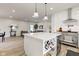 A view of the kitchen, its island with a wine rack, and open sightlines into the living and dining areas at 4804 Brouse Ave, Indianapolis, IN 46205