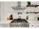 This kitchen features a commercial-grade range, vent hood, and floating wood shelves at 4804 Brouse Ave, Indianapolis, IN 46205