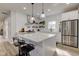 The modern white kitchen features stainless appliances, granite countertops, and stylish pendant lighting at 4804 Brouse Ave, Indianapolis, IN 46205