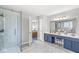 Bathroom showcasing a tiled shower, double vanity with a makeup table, and modern lighting at 4947 Cherryhill Ct, Indianapolis, IN 46254