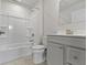 A bathroom with a shower and bathtub combo, a grey vanity, and a white toilet at 5147 Gerhing Dr, Indianapolis, IN 46239