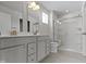 This modern bathroom features double sinks, a shower with glass doors, and neutral tile at 5147 Gerhing Dr, Indianapolis, IN 46239
