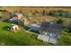 Aerial view of a property with multiple buildings, including a brick home, barn, and a well-maintained landscape at 5752 River Rd, Waldron, IN 46182