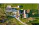 Bird's-eye view of a sprawling property with multiple buildings, lush greenery, and winding driveways at 5752 River Rd, Waldron, IN 46182