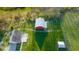 Aerial view showcasing the home and outbuildings amid expansive green fields and lush greenery at 5752 River Rd, Waldron, IN 46182