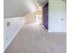 Carpeted attic space with built-in shelves, a door, and a dormer window at 5752 River Rd, Waldron, IN 46182