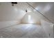 Spacious carpeted attic featuring a dormer window and a ceiling fan at 5752 River Rd, Waldron, IN 46182