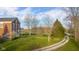 Expansive backyard of a brick home showcasing a lush lawn, mature trees, and rolling hills at 5752 River Rd, Waldron, IN 46182