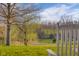 Picturesque view from the backyard of a lush lawn, mature trees, and rolling hills at 5752 River Rd, Waldron, IN 46182